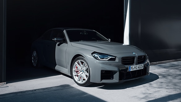 Graues BMW 2er Coupé M Automobil parkend in einer Garage, Fokus auf den linken Scheinwerfer