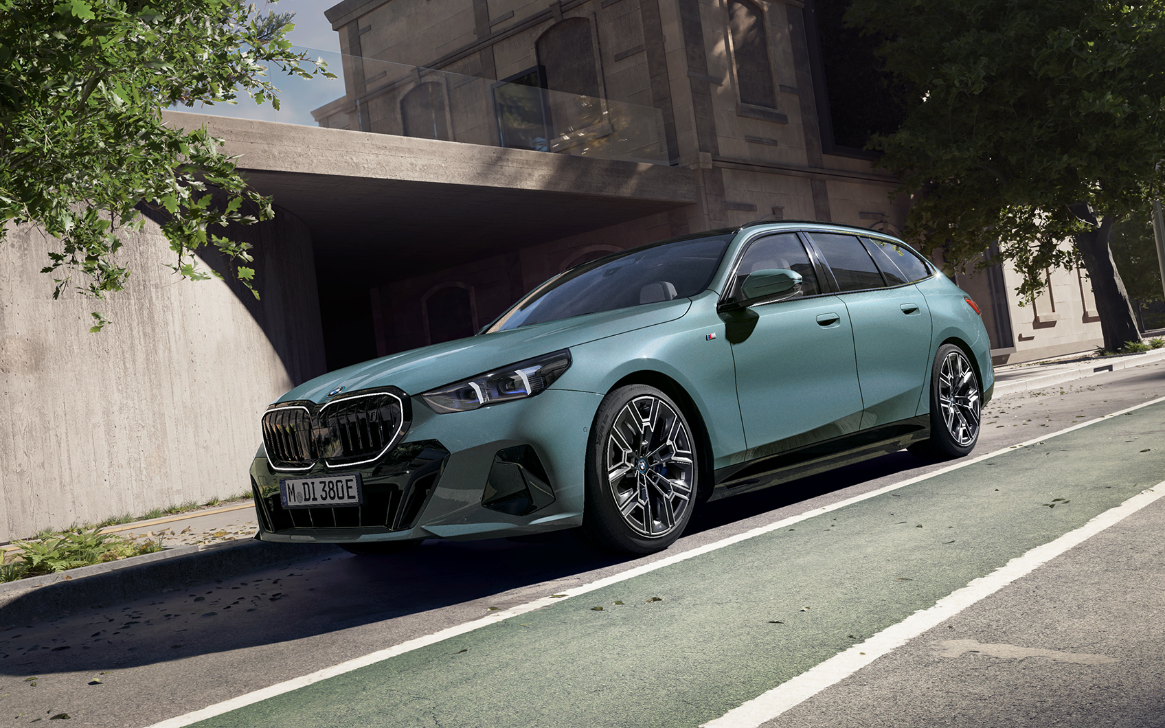 Grüner BMW i5 Touring parkt am Straßenrand, auffällige Nieren und schlanker Scheinwerfer