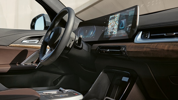 BMW iX1 Interieur mit BMW Curved Display, Leder- und Holzdetails an Armaturenbrett