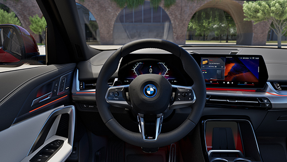 BMW iX2 Interieur mit Lenkrad, BMW Curved Display und modernem Design in Parkumgebung