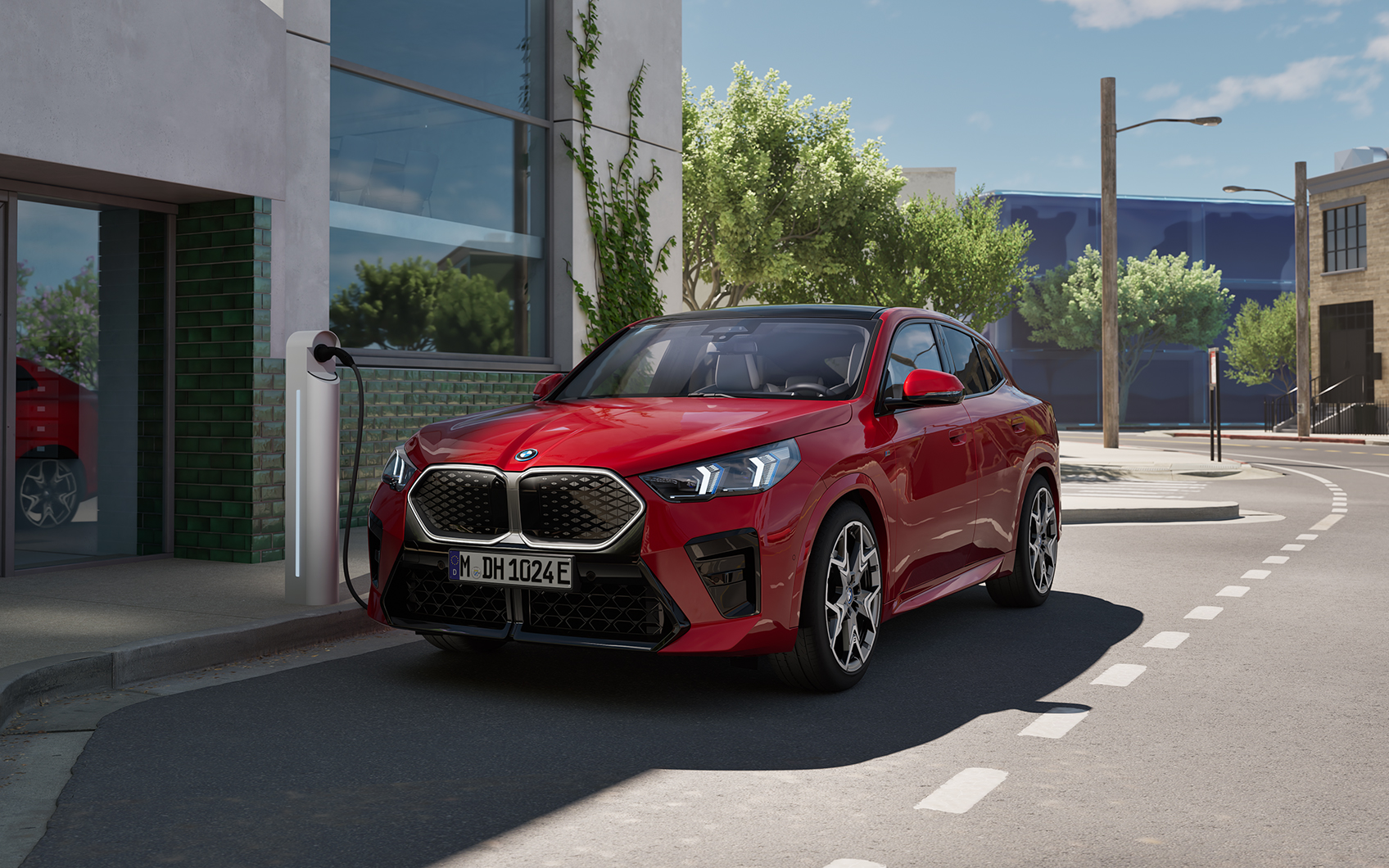 Roter BMW iX2 parkt an öffentliche Elektro-Ladesäule an der Straße, in urbaner Umgebung