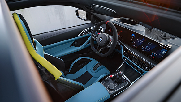 Interieur des BMW M4 Competition Coupé mit Fokus auf den blau-schwarzen Fahrersitz, das Lederlenkrad und die Bedienelemente