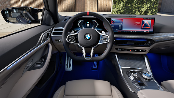 Cockpit des BMW 4er Gran Coupé M Automobil aus Sicht des Fahrers mit Lederlenkrad, BMW Curved Display und Bedienelementen