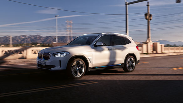 Vollelektrisches BMW iX3 SUV in dynamischer Fahrt auf städtischer Straße