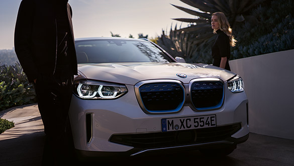 Weißer BMW iX3 von vorne, Betonung auf charakteristischer Nierenform und LED-Scheinwerfern