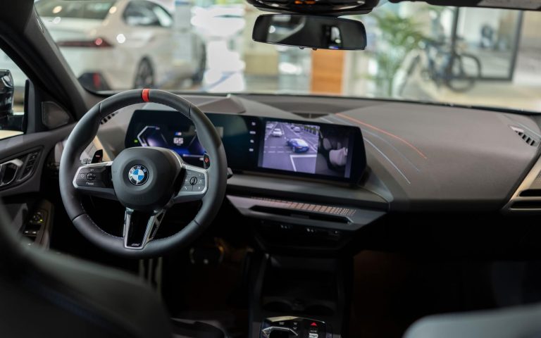 Das Cockpit des BMW M135 mit Blick auf das Sportlenkrad, BMW Curved Display und die Interieurleisten