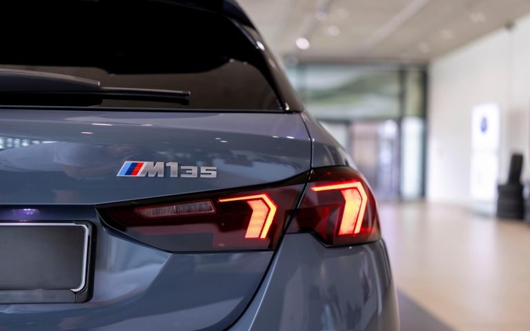 Heckansicht auf den BMW M135 im Showroom von der Automag, Fokus auf Motorisierung