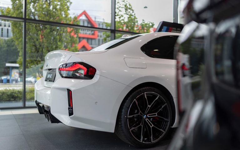 Seitenansicht auf den BMW M2 Coupé im Showroom der Automag, Fokus liegt auf dem Heck