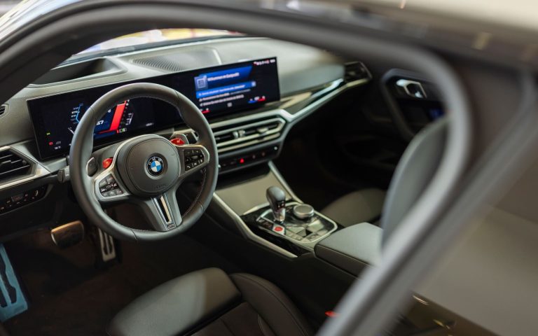 Cockpit eines BMW M2 Coupé im Malboro Design, fotografiert durch die Fahrertür mit Fokus auf das BMW Lenkrad und die Bedienelemente im Showroom der Automag