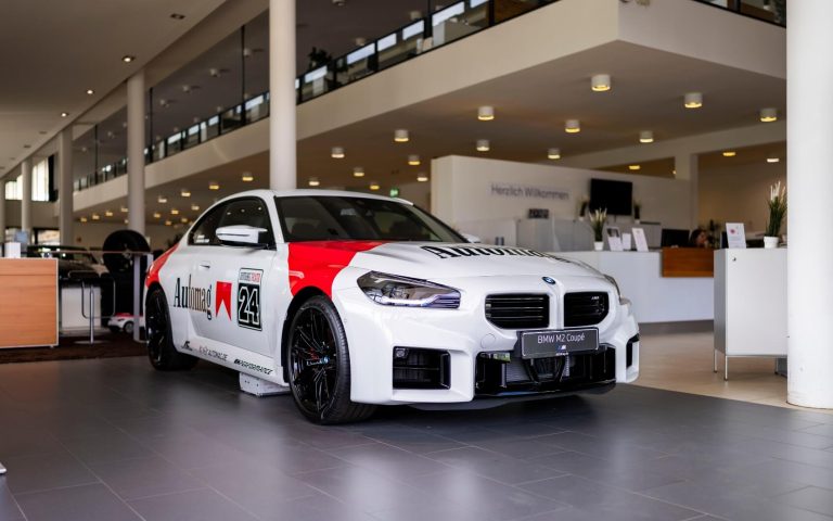 Frontansicht auf ein BMW M2 Coupé mit Malboro Aufschrift im Showroom der Automag, Fokus auf den rechten Frontscheinwerfer und rechten Vorderreifen