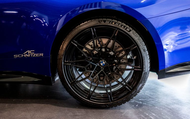 Linker Hinterreifen eines BMW M4 Competition Coupé in der Farbe Dunkelblau getunt von AC Schnitzer, aufgenommen im Showroom der Automag