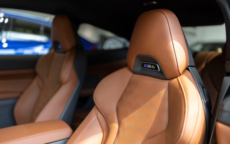 Detailaufnahme des Fahrer- und Beifahrersitzes eines BMW M4 Competition Coupé aus Leder in der Farbe braun, aufgenommen im Showroom der Automag