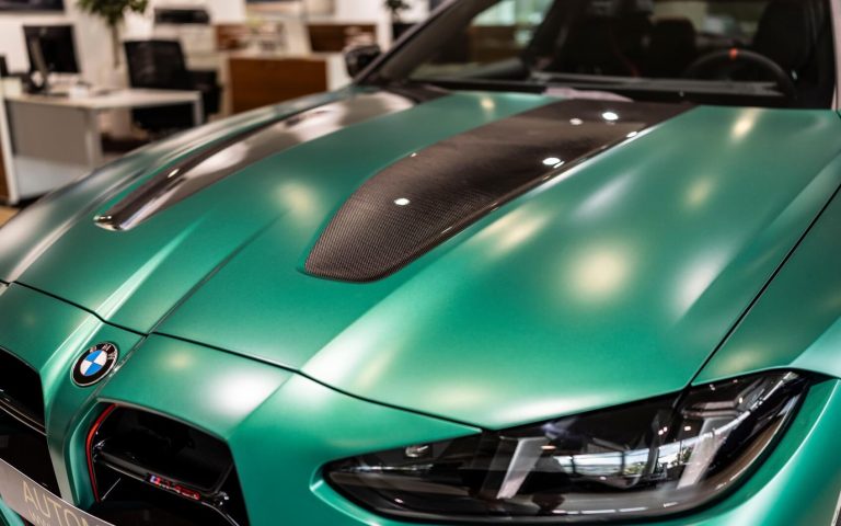 Motorhaube eines BMW M4 Coupé in der Farbe Grün, aufgenommen im Showroom der Automag