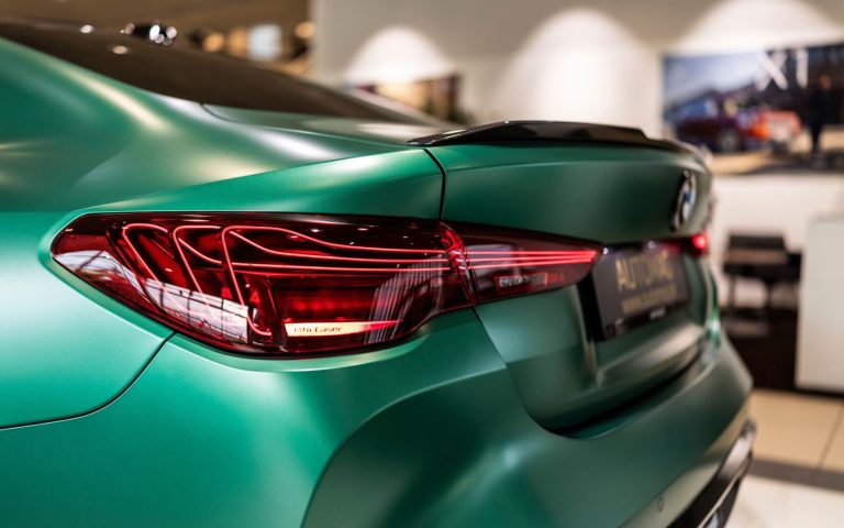 Detailaufnahme der linken Heckleuchte eines BMW M4 Coupé in der Farbe Grün, aufgenommen im Showroom der Automag