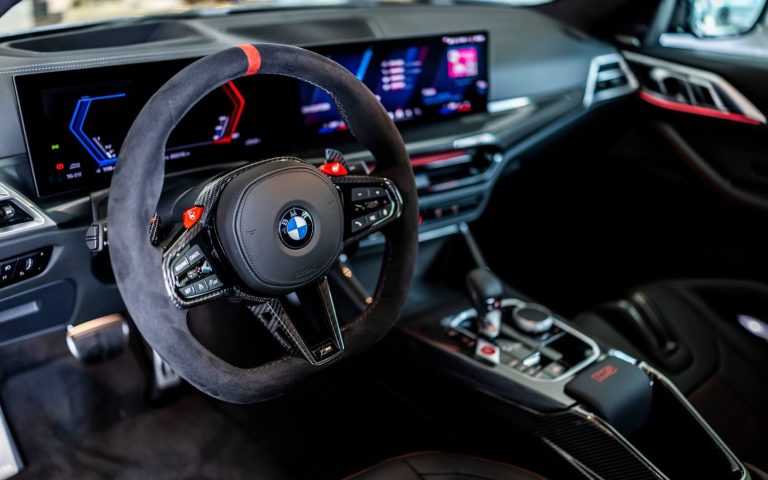 Cockpit des BMW M4 Coupé mit Fokus auf das BMW M Lenkrad und das Display, aufgenommen aus der Fahrerperspektive im Showroom der Automag