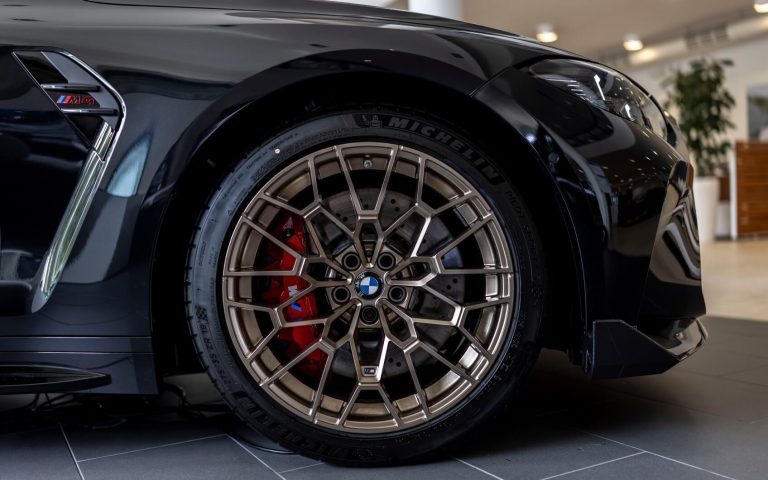 Rechter Vorderreifen mit Felgen aus Bronze eines BMW M4 Coupé in der Farbe schwarz, aufgenommen im Showroom der Automag