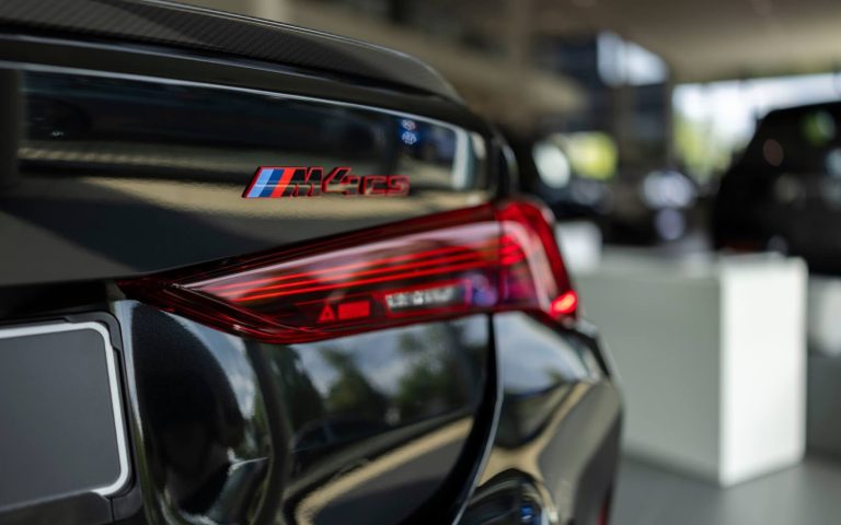 Detailaufnahme der rechten Heckleuchte eines BMW M4 Coupé in der Farbe Schwarz, aufgenommen im Showroom der Automag