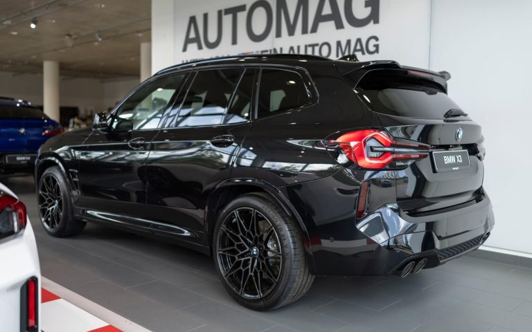 Heckaufnahme eines BMW X3 M Competition in der Farbe Schwarz mit Fokus auf der linken Heckleuchte und den linken Hinterreifen, aufgenommen im Showroom der Automag