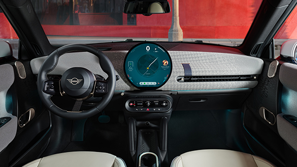 Detailansicht des Armaturenbretts, Lenkrads und digitalen Displays im Innenraum des MINI Cooper Electric von Fahrersitz aus.