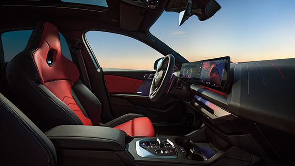 Cockpit eines BMW 2er Gran Coupé mit Sportsitzen aus Veganza perforiert in den Farben Korallrot und Schwarz, Sportlenkrad, BMW Curved Display und optionalen beleuchteten Aluminium-Dekorleisten