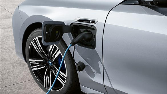 Ladeanschluss eines BMW 7er Plug-in-Hybrid mit eingestecktem Ladekabel an der linken Fahrzeugseite.