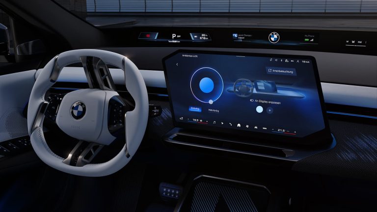 Digitales Cockpit eines BMW iX3 mit großem Touchdisplay und weißem Lenkrad.