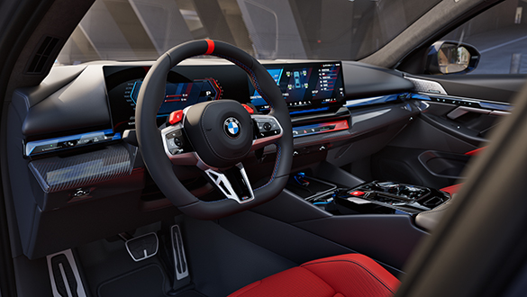 Blick von der Fahrerseite ins Cockpit einer BMW M5 Limousine mit Leder Merino Rot/Schwarz, M Multifunktionssitzen, M Lenkrad, BMW Curved Display und Mittelkonsole