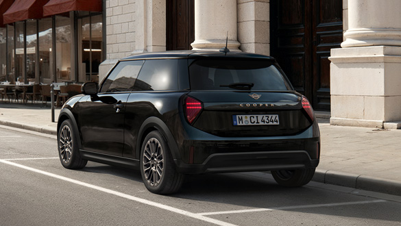 Heckansicht eines schwarzen MINI Coopers vor einem Gebäude mit Säulen und dunklen Türen.