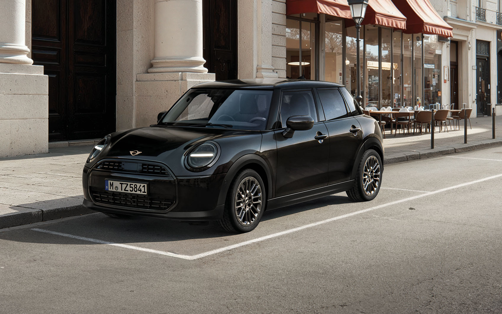 MINI Cooper 5-Türer Blackyard parkt am Straßenrand vor mondäner Stadtlandschaft