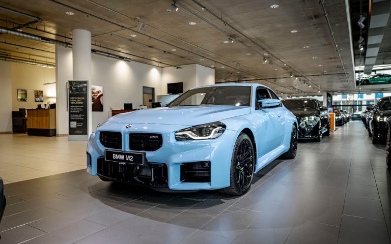 Hellblauer BMW M2 im Autohaus, Frontansicht schräg von links