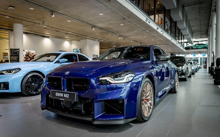Blauer BMW M2 CS im Autohaus, Frontansicht schräg von links