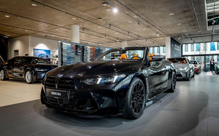 Schwarzes BMW M4 Cabrio im Autohaus, Frontansicht schräg von links