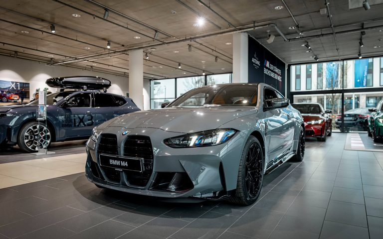 Grauer BMW M4 im Autohaus, Frontansicht schräg