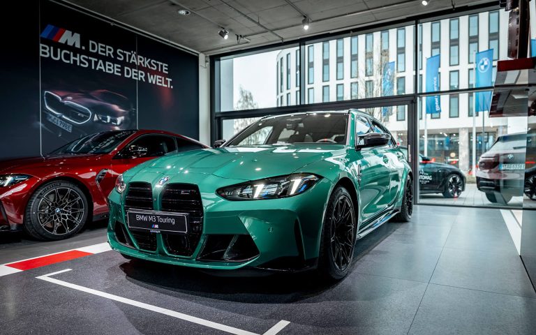 Grüner BMW M3 Touring im Autohaus, Frontansicht schräg von links