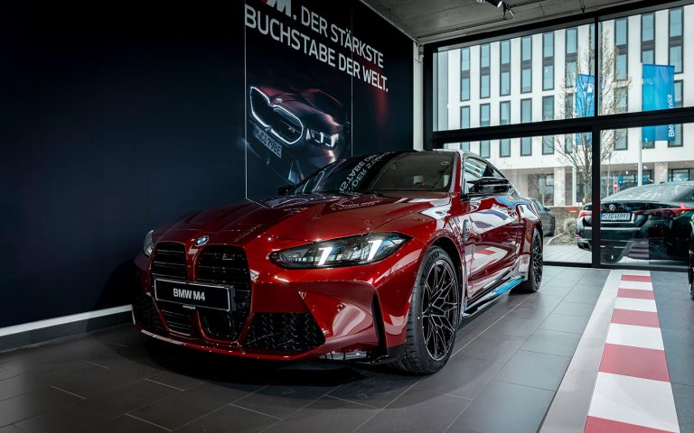 Roter BMW M4 im Autohaus, Frontansicht schräg