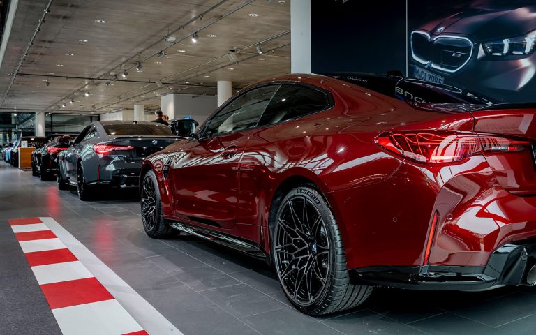 Roter BMW M4 im Autohaus, Heckansicht schräg
