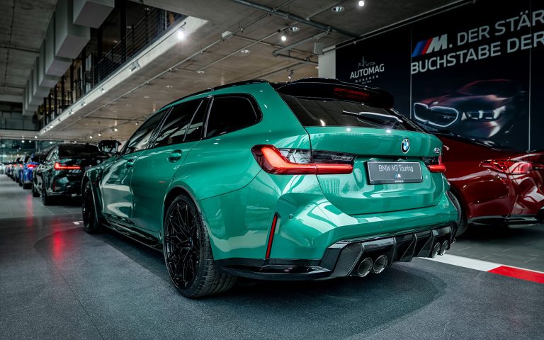 Grüner BMW M3 Touring im Autohaus, Heckansicht schräg von links