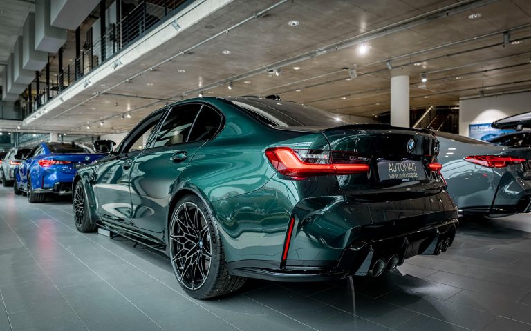 Dunkelgrüner BMW M3 Competition im Autohaus, Heckansicht schräg