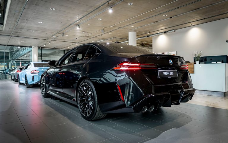 Schwarzer BMW M5 im Autohaus, Heckansicht schräg