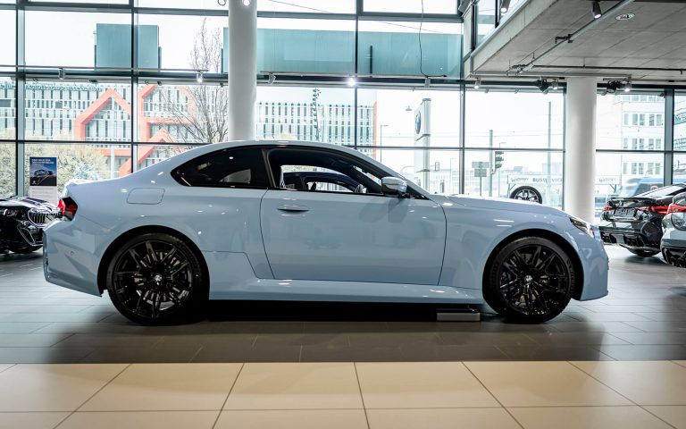 Hellblauer BMW M2 in Seitenansicht im Autohaus