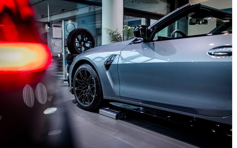 Graues BMW M4 Competition Cabrio mit Seitenlinie und Vorderrad