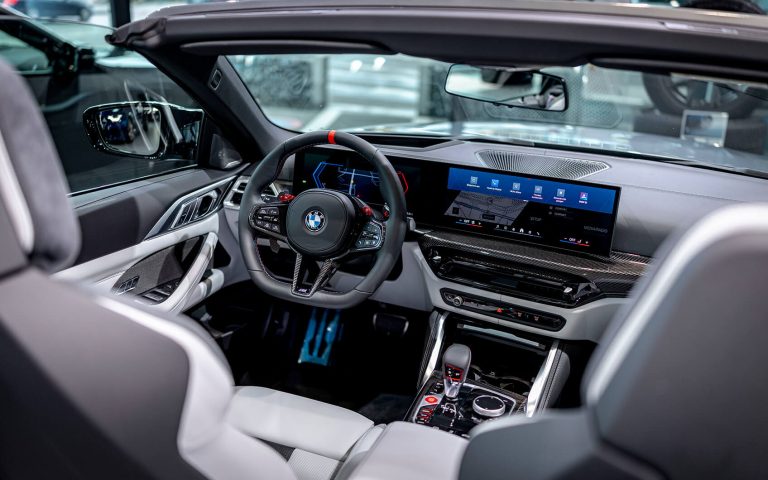 BMW M4 Competition Cabrio Cockpit aus Rücksitzperspektive, Fokus auf Fahrerseite