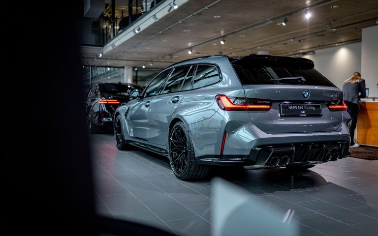 Grauer BMW M3 Touring im Autohaus, Heckansicht schräg