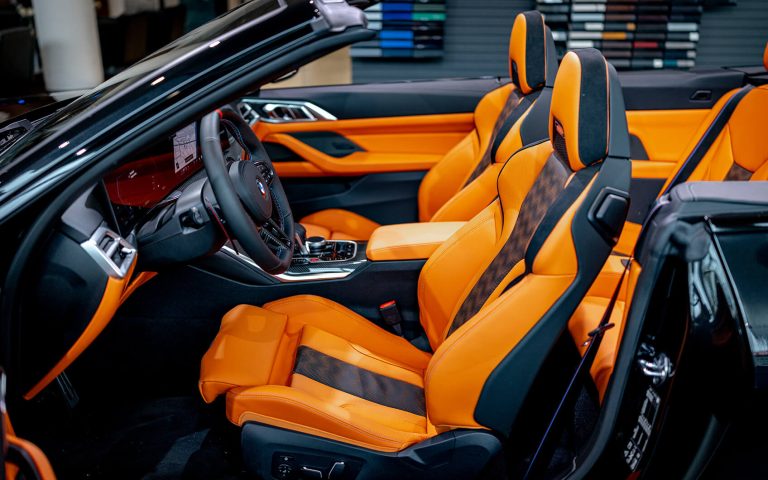BMW M4 Cabrio Innenraum mit Sportsitzen und offener Fahrertür