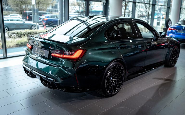 Dunkelgrüner BMW M3 Competition im Autohaus, Heckansicht mit Seitenprofil