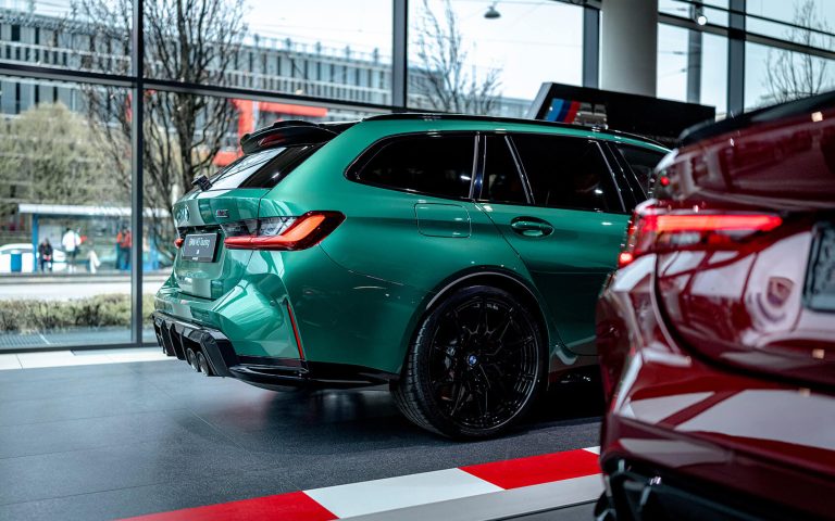 Grüner BMW M3 Touring im Autohaus, Seitenansicht schräg von hinten