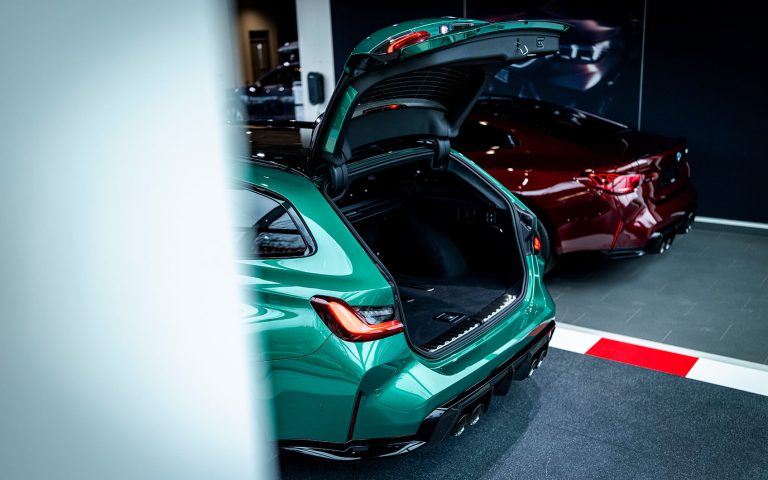 Grüner BMW M3 Touring mit geöffneter Heckklappe