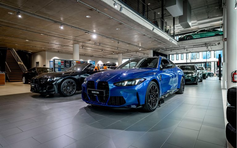 Blauer BMW M4 und schwarzes BMW M4 Cabrio im Autohaus