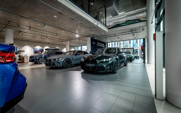 BMW Autohaus mit grünem BMW M3 Competition und weiteren M-Modellen