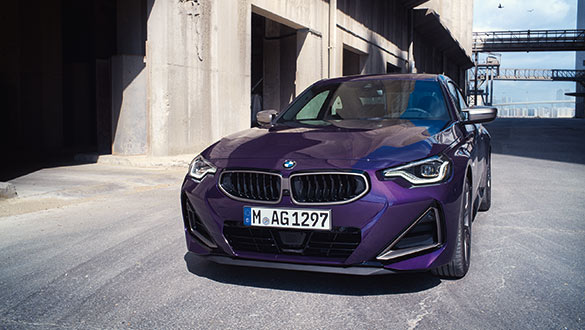 Frontansicht eines lila BMW 2er Coupé parkend in urban-industrieller Umgebung
